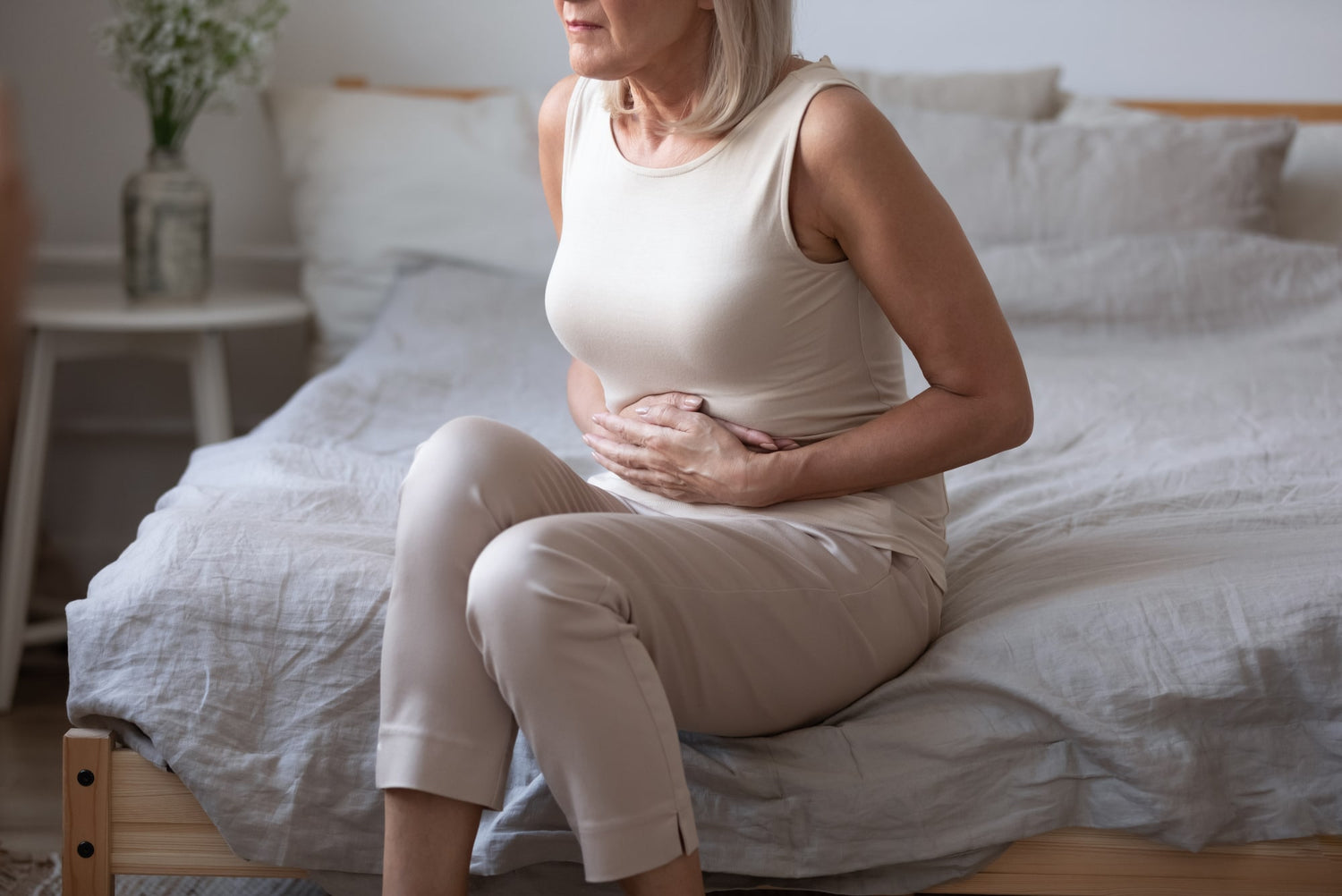 Gut Microbiome - Mature woman holding her stomach.